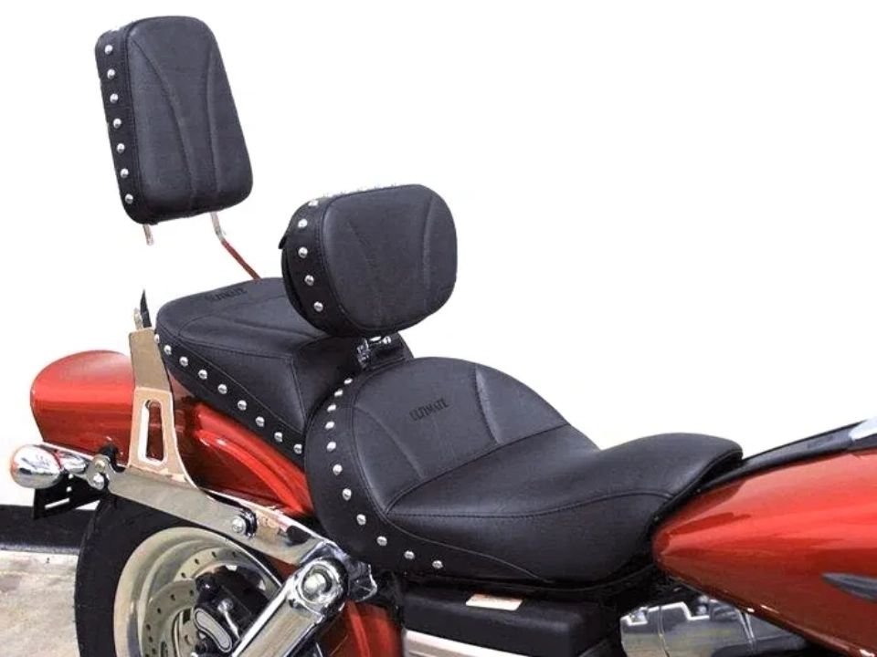 A red motorcycle featuring custom black leather seats with studded backrests for both rider and passenger.